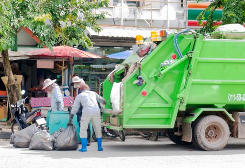 Workers loading mixed waste into a vehicle during a shop refit in Thamesmead